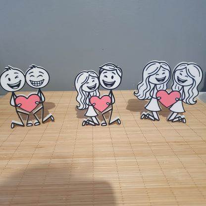 Présentation des trois modèles de couples inclusifs en 3D : homme-homme, homme-femme et femme-femme tenant un cœur rose.