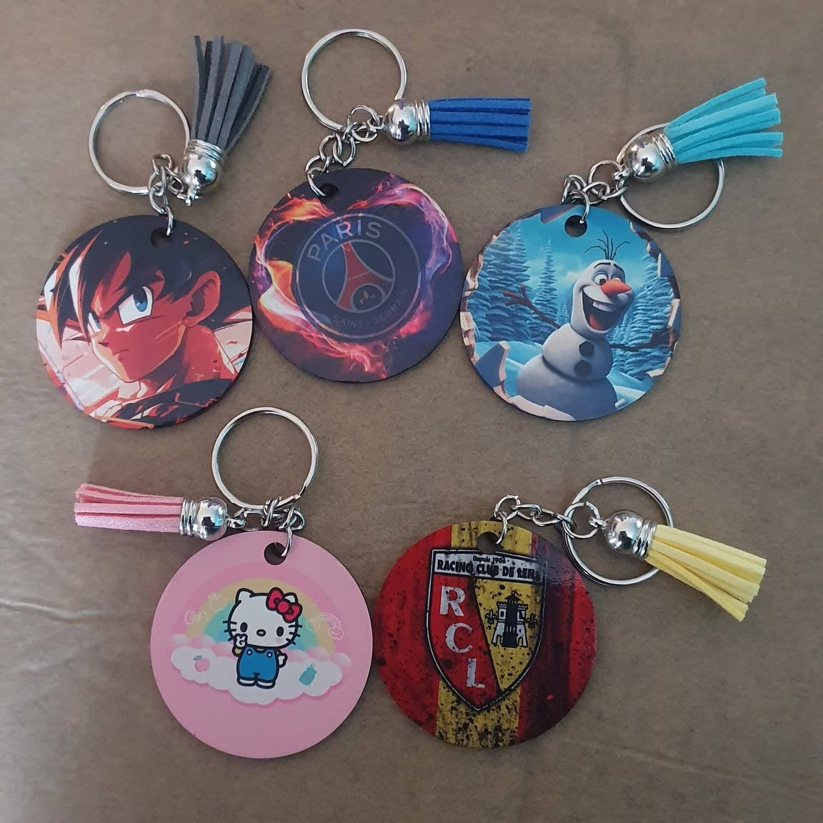 Assortiment de porte-clés ronds de 5cm avec exemples de visuels démonstratifs et pompons colorés
